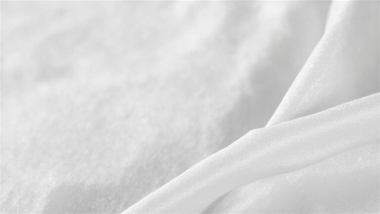 Close-up of polyester fabric texture alongside care label showing heat-sensitive washing instructions
