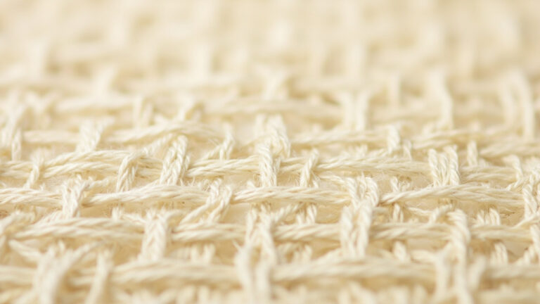 Magnified plain weave fabric showing 1/1 interlacing pattern with alternating over-under warp and weft threads