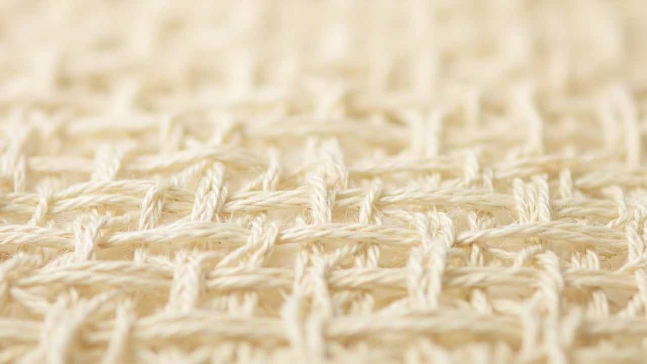 Magnified plain weave fabric showing 1/1 interlacing pattern with alternating over-under warp and weft threads