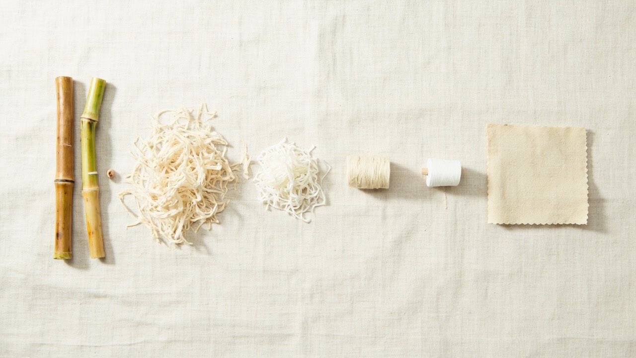Diagram illustrating the step-by-step manufacturing process of bamboo fabric from raw bamboo stalks to finished textile