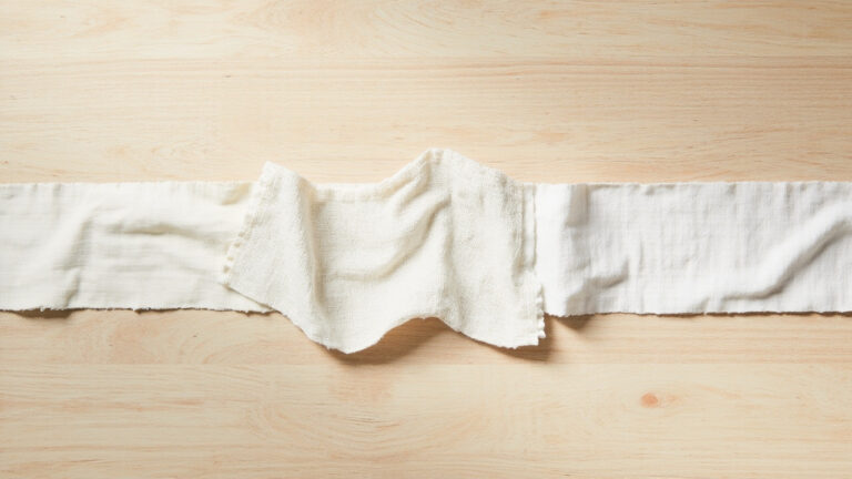 Comparison of bamboo fabric, organic cotton, and modal fabric swatches showing distinct textures and weave patterns