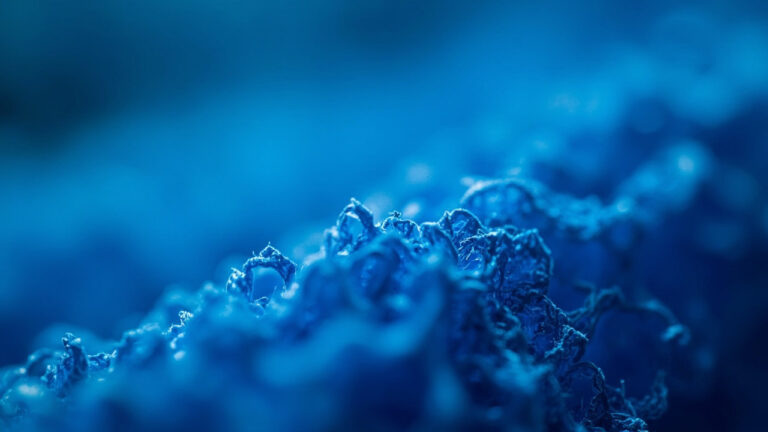 Macro close-up of blue microfiber fabric showing ultra-fine split fibers characteristic of synthetic microfiber textile