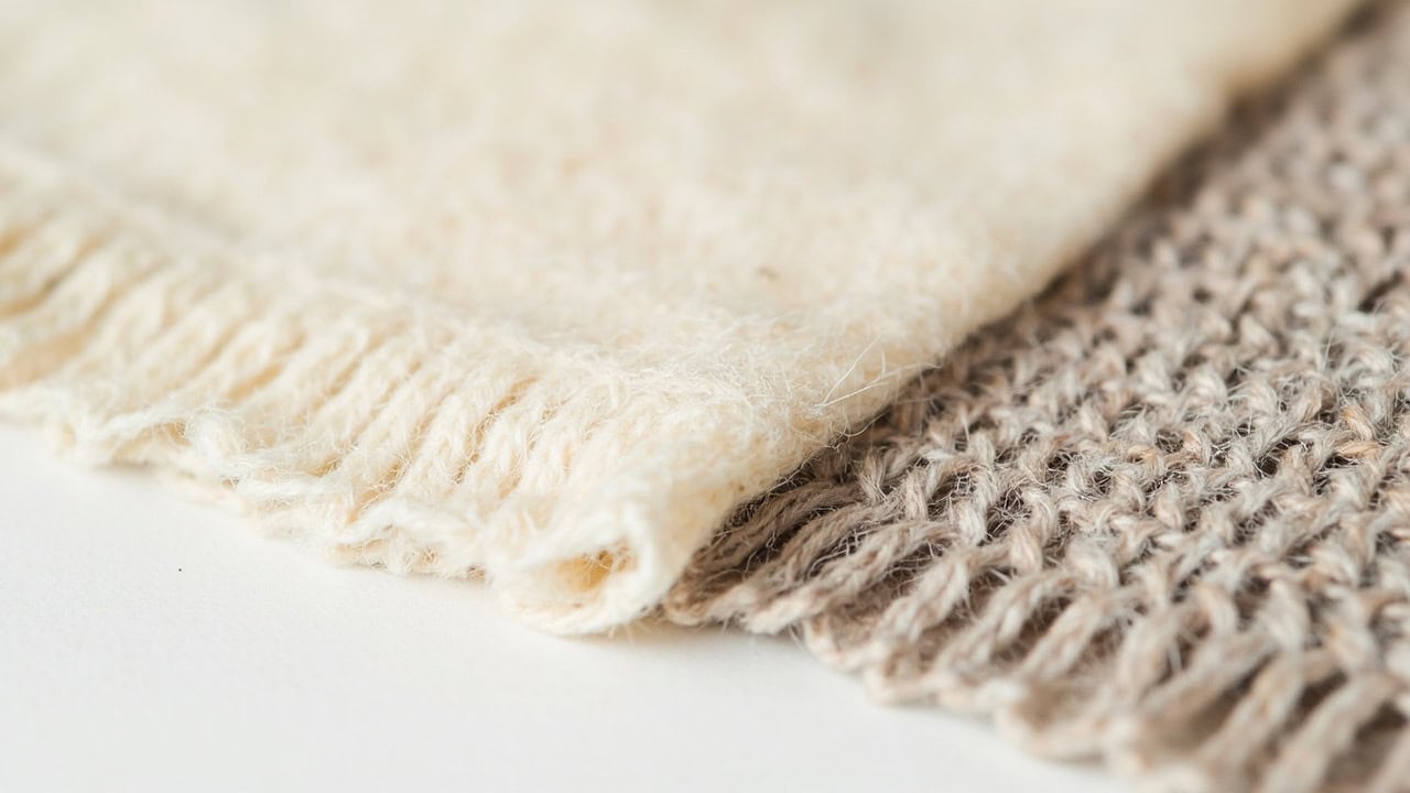Microscopic comparison of cashmere versus wool fibers showing difference in fineness and scale patterns