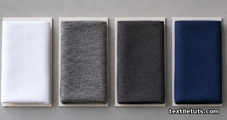 Four folded textile swatches laid side by side showing cotton poplin, polyester knit, worsted wool, and FR cotton.