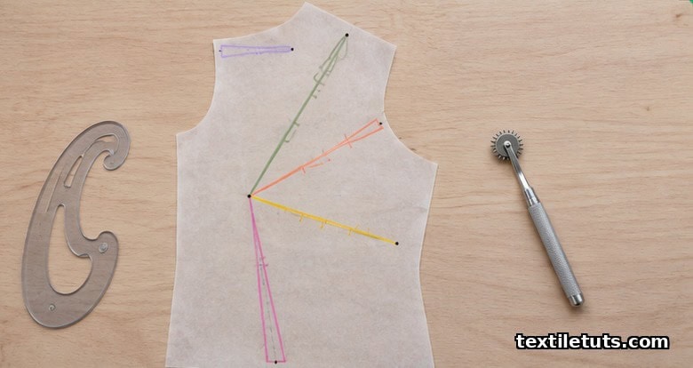 Overhead view of a paper bodice pattern showing bust, waist, shoulder, French, and neck darts drawn in colored pencil on translucent paper.