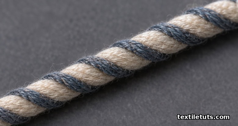 Spiral yarn macro with a hard-twisted effect yarn wound around a softer ground yarn forming a regular corkscrew pattern.