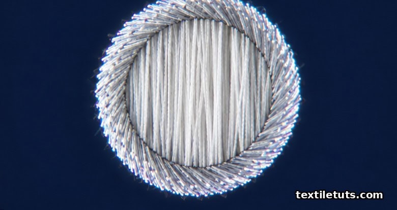 Microscopic cross-section of vortex-spun yarn showing the parallel untwisted core fibers surrounded by a tight ring of wrapper fibers at a high helix angle.