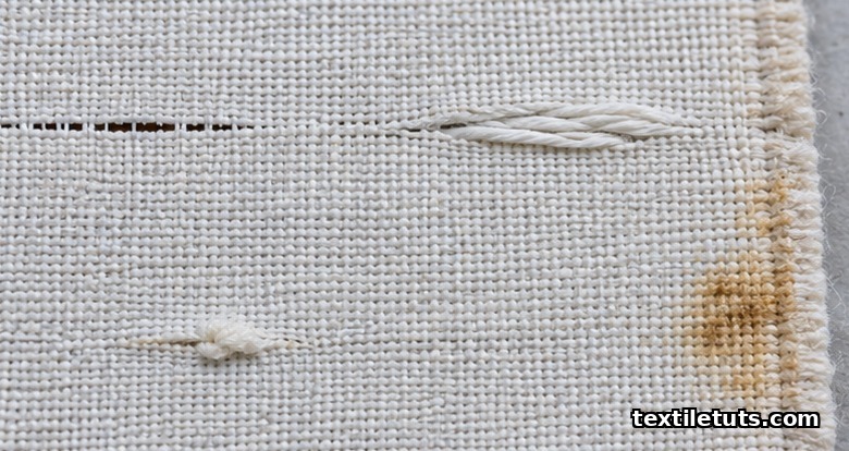 Close-up of woven cotton fabric showing broken picks, floats, slubs, and an oil stain as common weaving defects under inspection lighting.