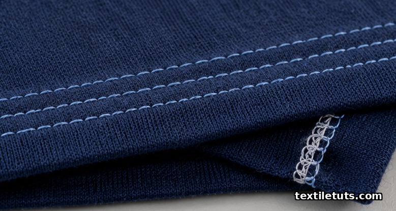 Macro of three parallel topstitch rows on a navy knit hem with the interlocked looper chain visible on the underside.