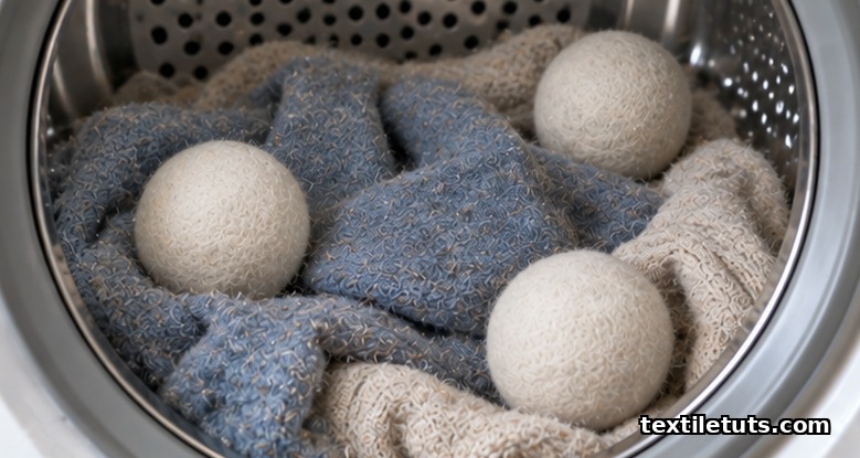 Wool dryer balls inside a tumble dryer drum with damp wool knits showing early matting and pilling
